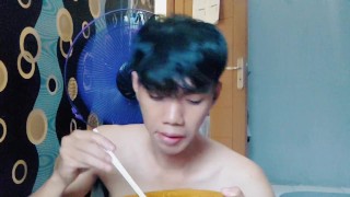 Handsome young man is eating noodles without using t shirt