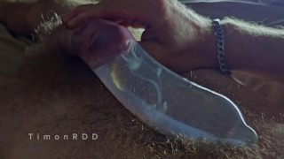 The guy cums in a condom with hot water with powerful volleys