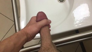 Cum flows down the wall of a public toilet