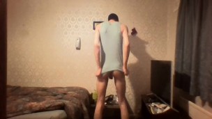 Very skinny twink with a cap strokes his cock while wearing a tank top